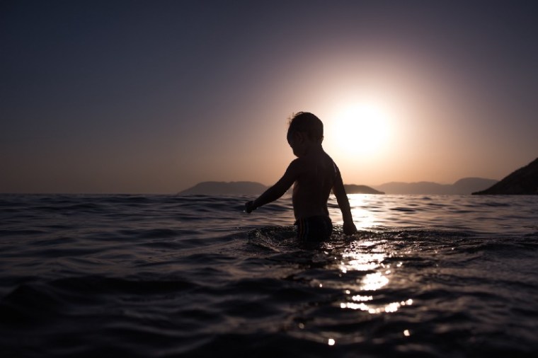 Child wading, silhouetted in sunlight