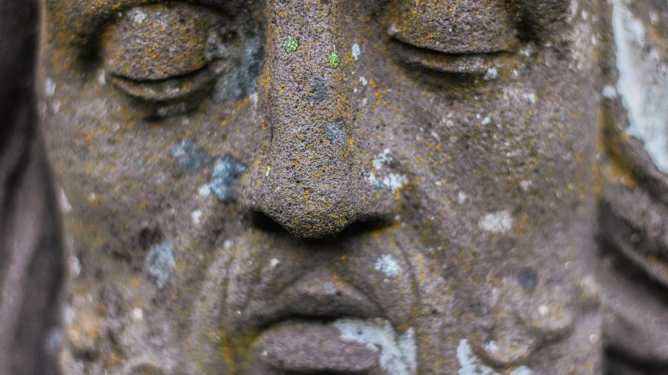 Close up of carved face of a man with closed eyes.