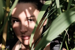 Woman looking out through wide-bladed foliage