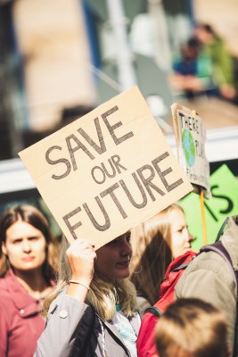 A young woman at a demonstration holds a sign that says "Save Our Future"